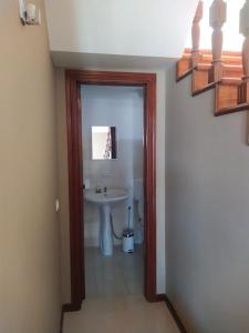 明德卢Vivenda com pátio, no coração do Mindelo的走廊上设有带水槽和镜子的浴室