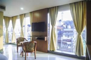 古瓦哈提HOTEL APOLLO GRAND A UNIT OF SATYAM ASSOCIATES的客房设有桌椅和窗户。