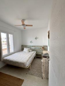 卡拉布兰卡Mar i Vent的一间卧室配有一张床和吊扇