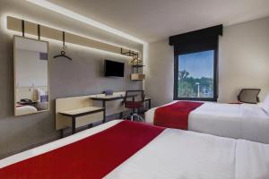 莱昂莱昂城市快捷酒店的酒店客房设有两张床、一张书桌和一个窗户。