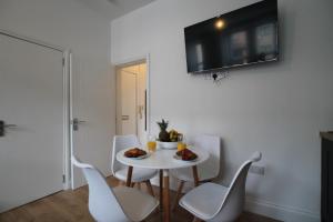 邓迪Superb One Bedroom Apartment in Dundee的白色的用餐室配有白色的桌椅