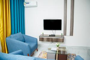 奇帕塔Modern Village Apartments的客厅配有蓝色椅子和电视