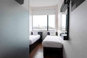 阿姆斯特丹阿姆斯特丹市中心南便捷酒店的小房间设有两张床和窗户