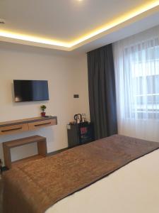 安塔利亚Hotel Kriti的一间卧室设有一张床、一台电视和一个窗口。