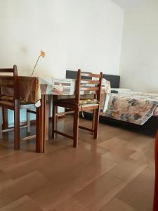 诺瓦拉Bellini Apartment's的一间带桌椅和一张床的用餐室