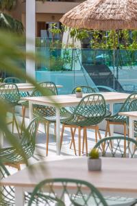 帕尔马诺瓦MarSenses Rosa del Mar Hotel & Spa的庭院里摆放着桌椅和遮阳伞