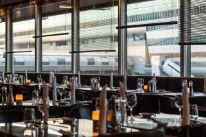 美因河畔法兰克福Frankfurt Airport Marriott Hotel的餐厅配有桌椅,后方有火车