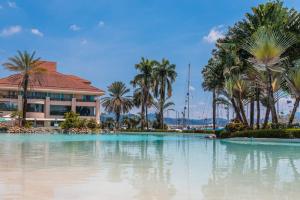 奥隆阿波The Subic Bay Yacht Club, Inc.的一座棕榈树游泳池和一座建筑