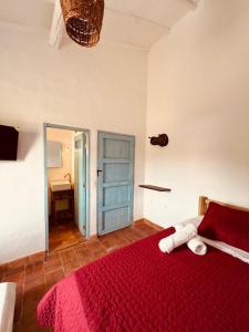 巴里查拉Casa Quintanilla Barichara的一间卧室配有红色的床和红色毯子