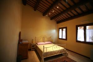 Cinto EuganeoB&B Contarine的一间卧室配有一张床、一张桌子和两个窗户
