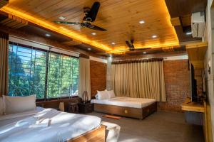 斯里曼加尔乌帕齐拉Lemon Garden Resort & Spa的一间卧室设有两张床和大窗户