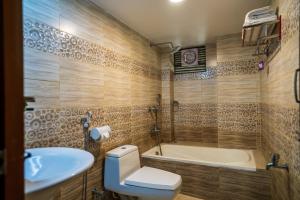 斯里曼加尔乌帕齐拉Lemon Garden Resort & Spa的浴室配有卫生间、盥洗盆和浴缸。