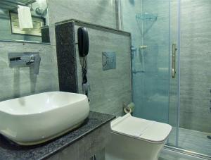 古瓦哈提HOTEL APOLLO GRAND A UNIT OF SATYAM ASSOCIATES的一间带卫生间、水槽和电话的浴室