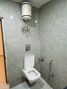 新德里Airport KINGDOM的浴室配有卫生间和墙上的灯。