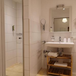 迪森阿姆阿梅尔塞Ferienwohnung Gutshof in Seenähe的带淋浴、盥洗盆和镜子的浴室