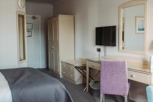 罗斯卡伯里Celtic Ross Hotel & Leisure Centre的酒店客房配有书桌和床。