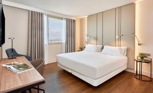 阿利坎特NH阿利坎特酒店的酒店客房设有一张白色大床和一张书桌