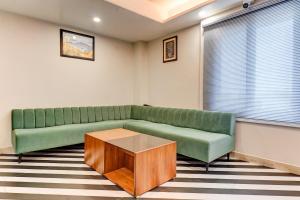 博帕尔Palette - Hotel Ocean Breeze的客厅配有绿色沙发和茶几
