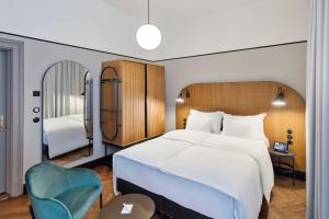 维也纳Hotel Astoria Wien的卧室配有一张白色大床和一张蓝色椅子