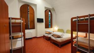 渥尔特拉沃尔泰拉基奥斯特罗德尔莫纳切旅馆的一间带两张双层床的房间和一间带床的房间