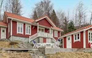 Amazing Home In Eiksund With Kitchen的前面有两把椅子的红色房子