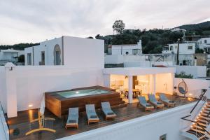 卡拉索斯Kalathos Square luxury suites的一个带椅子的阳台和一个位于大楼内的游泳池
