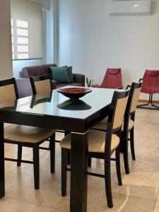 门多萨DEPARTAMENTO Céntrico MENDOZA的一张带椅子和沙发的黑色餐桌