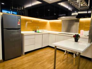 蕉赖Eshue Designer Suites @ Simfoni Towers的厨房配有不锈钢冰箱和桌子