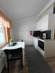 AavasaksaAava Sky Village Aurinkomaja的厨房配有白色橱柜、桌子和炉灶。