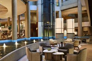 洛杉矶The Westin Bonaventure Hotel & Suites, Los Angeles的大楼内带桌椅的大堂