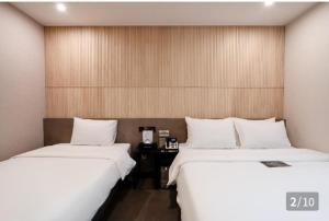 SeosanHotel 24st Prestige的两张睡床彼此相邻,位于一个房间里