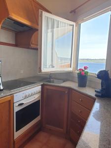 福尔内利斯F76. Vistas al mar en Fornells!的厨房设有水槽和窗户。