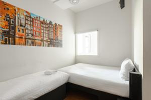 阿姆斯特丹阿姆斯特丹市中心南便捷酒店的墙上画画的房间里设有两张床