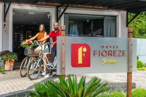 格拉玛多Hotel Fioreze Primo的旁边一辆自行车上的男女
