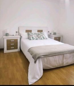 Puente CaldelasVeiga de Cima的一间卧室配有一张带2个床头柜的大床