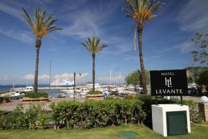 卡沃Hotel Levante - Isola d'Elba的棕榈树码头前的标志