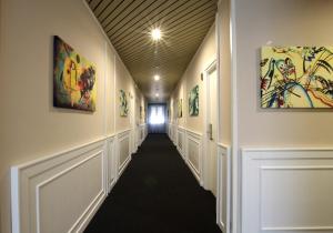 卡沃Hotel Levante - Isola d'Elba的建筑墙上的走廊上挂有绘画作品