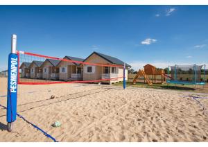 米耶伦科Morska Gąska- domki letniskowe的一个带排球网和游乐场的海滩