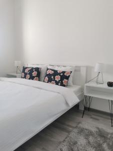 巴尼亚科维利亚查Apartmani Iva的一张带两个枕头和一张桌子的白色床