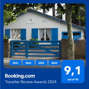 拉波勒Villa L'Herbaudière - La Baule les Pins的白色房子前面的蓝色围栏