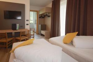 加尔达湖滨大使套房酒店的酒店客房设有两张床、一张桌子和一张书桌。