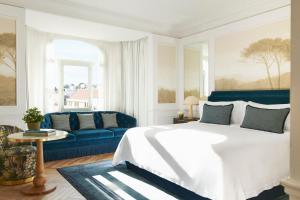马德里The Westin Palace, Madrid的一间卧室配有一张床和一张蓝色的沙发