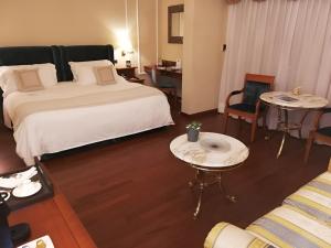 博尔迪盖拉戴尔玛尔度假及SPA大酒店的酒店客房带一张床、一张桌子和椅子