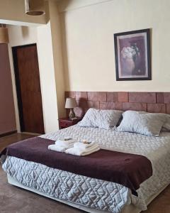 圣伊格纳西奥Portal del Sol的一间卧室配有一张大床和毛巾