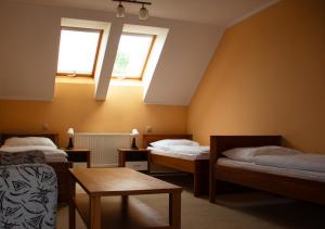 PružinaPenzión pod Strážovom的客房设有两张床、一张桌子和两个窗户。