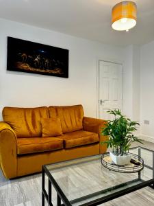 黑尔斯欧文Rooms Near Me - Apartment 2, Smart Tv, Free Parking的客厅配有棕色沙发和玻璃桌