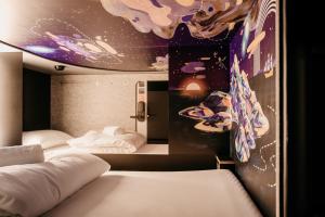 卢塞恩Capsule Hotel - Chapter Lucerne New Opening的墙上画画的房间里设有两张床