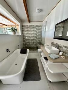 开普敦Blue Bay Studio Bayview的白色的浴室设有浴缸和水槽。