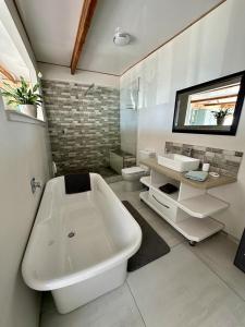 开普敦Blue Bay Studio Bayview的浴室配有大型白色浴缸和水槽