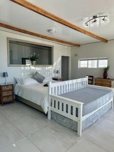 开普敦Blue Bay Studio Bayview的卧室配有一张白色大床和镜子